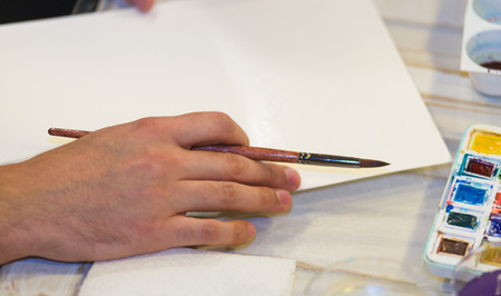 Hand holding a Paint Brush in a painting Classの写真素材