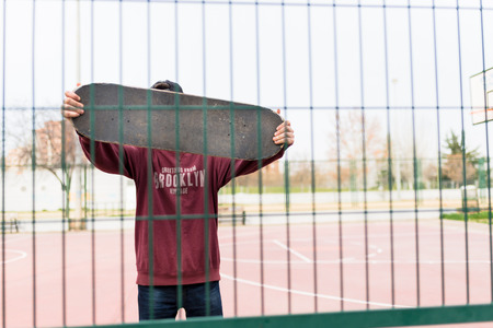 Behind a Fence with his Skate on a Courtの写真素材