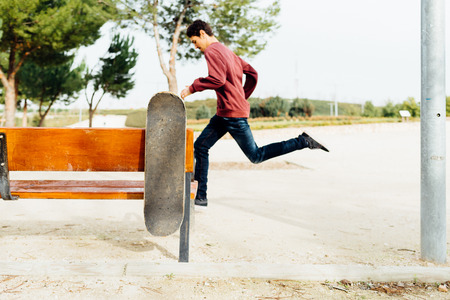 Man running & Skate holding on a street Bench in a sunny Day