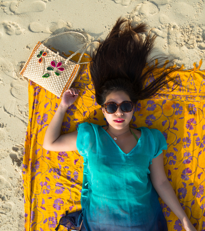 Pretty Asian Girl resting on the Beach with Fashion Glasses in Phuket Island