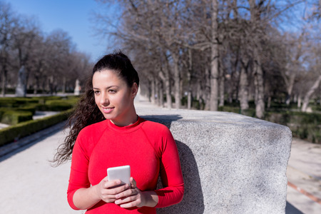 Woman smiling with her Phone in a Park in Madrid
