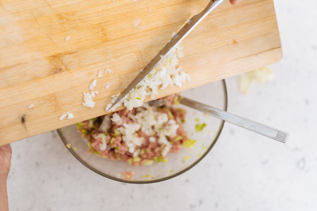 Adding Pieces of Onions into the fill of Dumplingsの写真素材