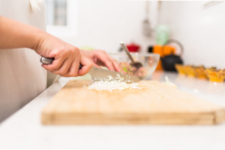 Female Hands Cutting Onion in the Kitchenの写真素材