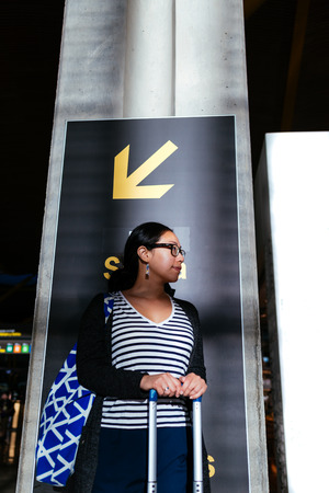 Woman in the airport with her HandLuggage and Bagの写真素材