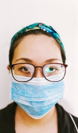coronavirus theme. Asian woman with glasses wearing a mask to protect herself from getting infectedの写真素材