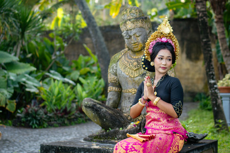 Woman in front of a Buddha statue in a costume and a crown in her hairの写真素材