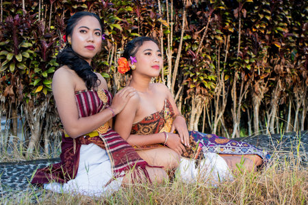 Bali two women in traditional costume at the park.の写真素材
