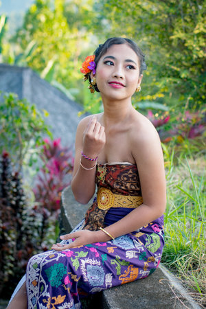 Beautiful Balinese woman in traditional costume in the garden,の写真素材