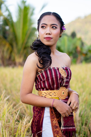 Beautiful Asian woman in traditional costume at rice field in Bali, Indonesiaの写真素材