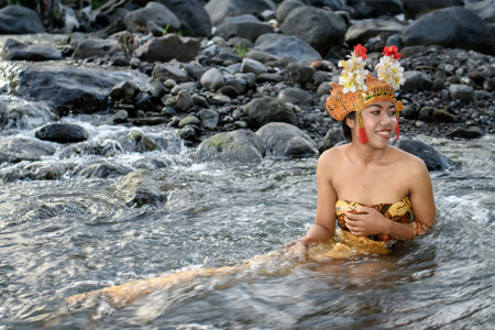 Unidentified Thai woman in traditional costume bathing in the river in Koh Samui, Thailand.の写真素材