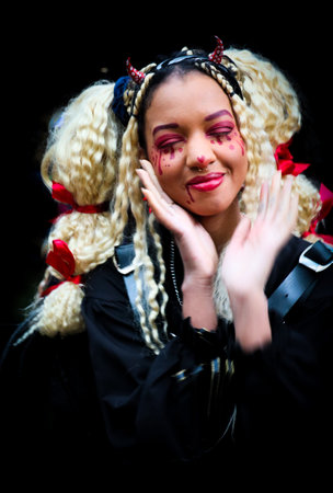 A beautiful woman of colour dressed brightly laughs to camera