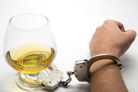 Alcohol and handcuffs - alcohol addiction conceptの写真素材