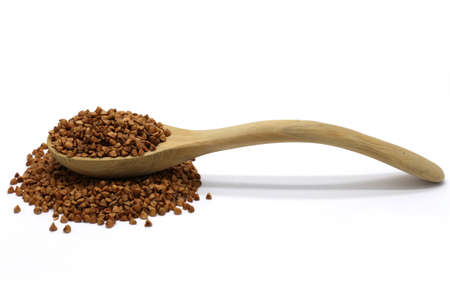 Buckwheat grains in wooden spoon on white isolated backgroundの写真素材
