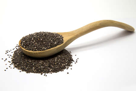 Chia seeds in a wooden spoon on white isolated backgroundの写真素材