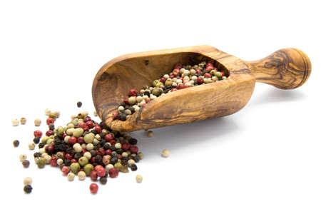 Mixed color pepper in wooden scoop on white isolated backgroundの写真素材