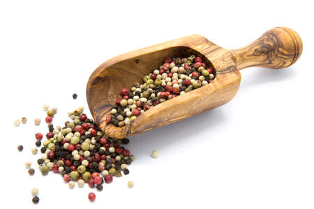 Mixed color pepper in wooden scoop on white isolated backgroundの写真素材