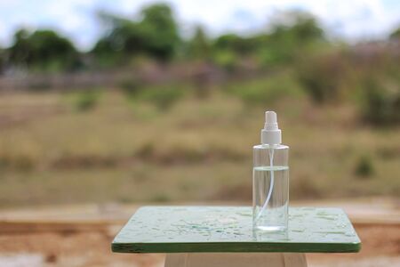 liquid alcohol 70% in clear bottle on the wood table nature backgroundの写真素材