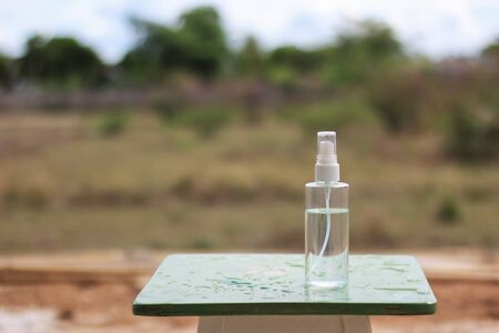 liquid alcohol 70% in clear bottle on the wood table nature backgroundの写真素材
