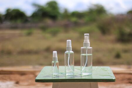 liquid alcohol 70% in clear bottle on the wood table nature backgroundの写真素材