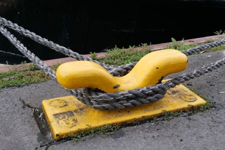 Yellow bollards on the harbor wall for attachment to the ship.