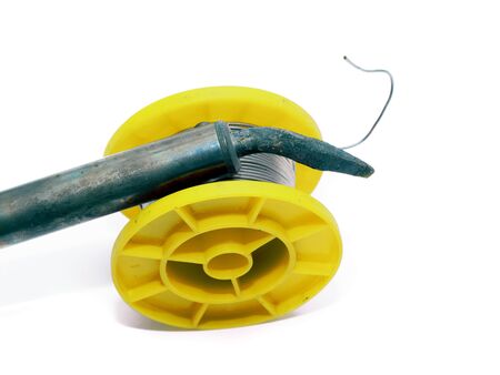 Yellow soldering tin roll with a soldering iron.の写真素材