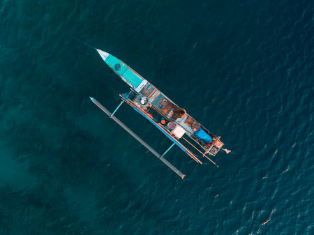 A bird eye view of traditional wooden boat on the blue water of the sea. Captured by droneの写真素材