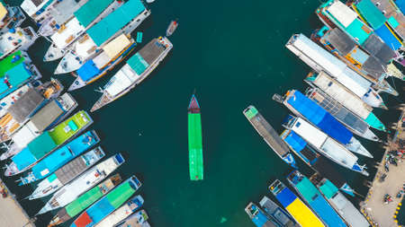Top view of sailing boats parking by the docks of a marina on Labuan Bajo, Indonesia