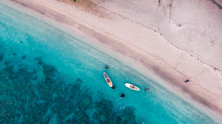 Aerial drone birds eye view of tourists canoeing in tropical beach of Moyo Island, Sumbawa, Indonesiaの写真素材