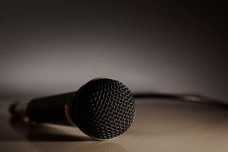 Microphone plugged in with wire on the ground in dramatic lighting. Music industry entertainment struggle emptyの写真素材