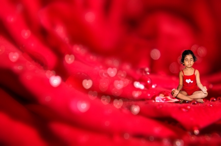 gild child meditating on macro red rose flower  abstract bokeh backgroundの写真素材