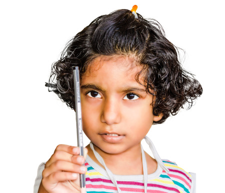 small indian asian girl child looking at pencil isolated on white backgroundの写真素材