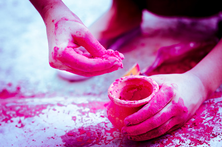 hands playing with colors    earthen pots backgroundの写真素材