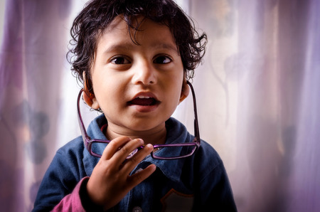 Portrait of asian Indian boy child smiling wearing eye glassの写真素材