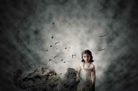 surreal magical portrait of small 5-10 years old indian asian fashionable stylish glamourous girl child with big eyes and unique hairstyle and traditional lehnga chunni dress posing and  looking straight into the camera on  abstract textured dreamy dramatの写真素材