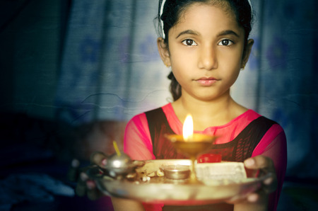 Indian asian girl child fire art portrait holding prayer plate welcomingの写真素材