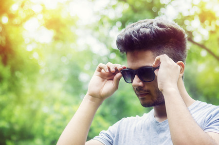 Stylish man wearing black shades portrait outdoor natural portrait with bokeh background