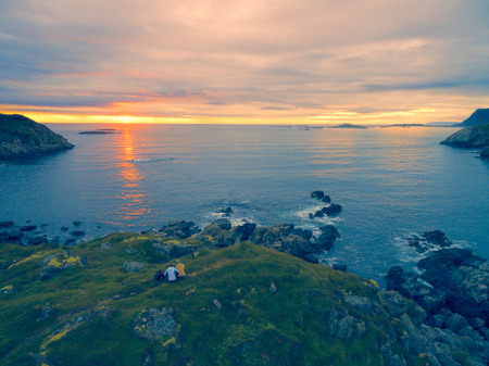Scenic view of midnight sun on rocky coast of Vesteralen inslands in Norwayの写真素材