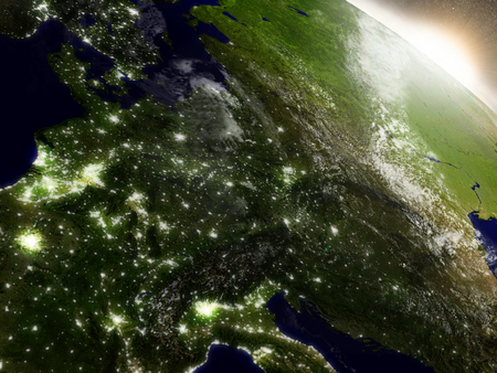 Central Europe with surrounding region during sunrise as seen from Earth's orbit in space. 3D illustration with highly detailed realistic planet surface, clouds and city lights.の写真素材