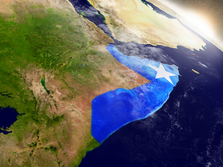 Somalia with embedded flag on planet surface during sunrise. 3D illustration with highly detailed realistic planet surface and visible city lights.の写真素材