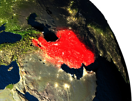 Iran highlighted in red on model of planet Earth with very detailed land surface and visible city lights. 3D illustration.の写真素材