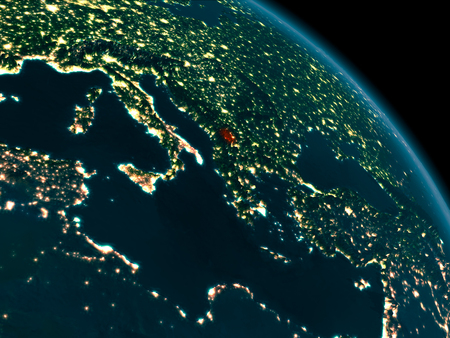 Orbit view of Kosovo at night highlighted in red on planet Earth with highly detailed surface textures. 3D illustration.の写真素材