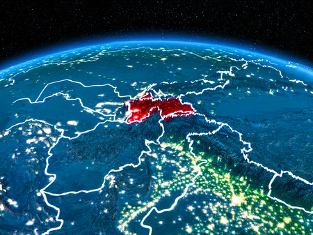 Orbit view of Tajikistan highlighted in red with visible borderlines and city lights on planet Earth at night. 3D illustration.の写真素材