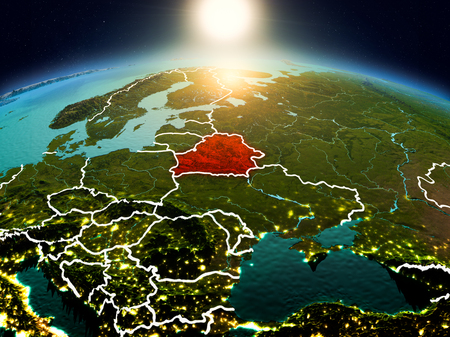Sunrise above Belarus highlighted in red on model of planet Earth in space with visible country borders. 3D illustration.の写真素材