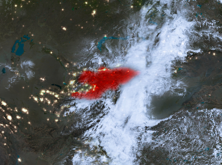 Country of Kyrgyzstan in red on planet Earth with clouds at night. 3D illustration.の写真素材