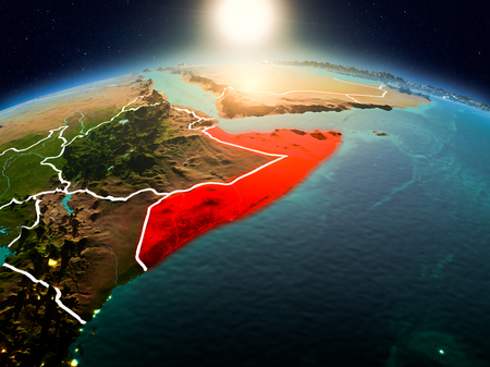 Sunrise above Somalia highlighted in red on model of planet Earth in space with visible country borders. 3D illustration.の写真素材