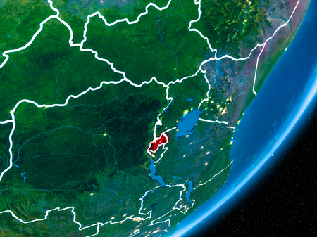 Rwanda in red on planet Earth at night with visible borderlines and city lights. 3D illustration.の写真素材