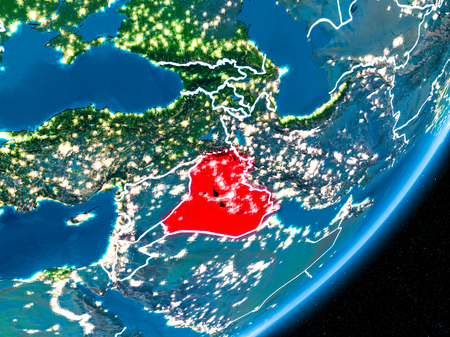 Iraq in red on planet Earth at night with visible borderlines and city lights. 3D illustration.の写真素材