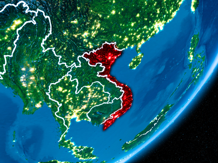 Vietnam in red on planet Earth at night with visible borderlines and city lights. 3D illustration.の写真素材