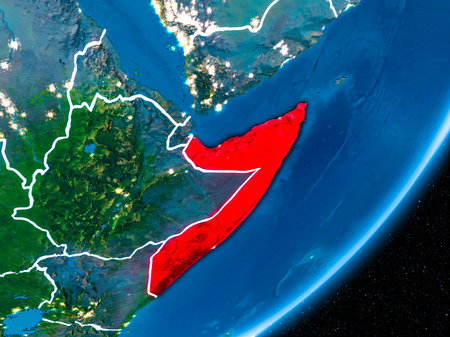 Somalia in red on planet Earth at night with visible borderlines and city lights. 3D illustration.の写真素材