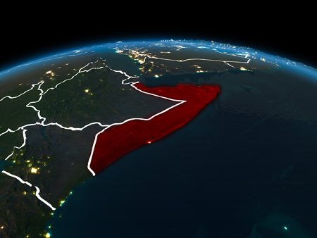 Space orbit view of Somalia highlighted in red on planet Earth at night with visible country borders and city lights. 3D illustration.の写真素材